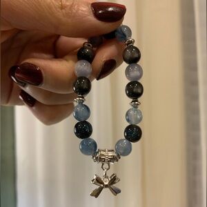 Blue and Black beaded bracelet with silver bow pendant
